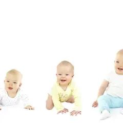Pięcioro dzieci w różnym wieku, od leżącego niemowlaka do stojącego malucha.