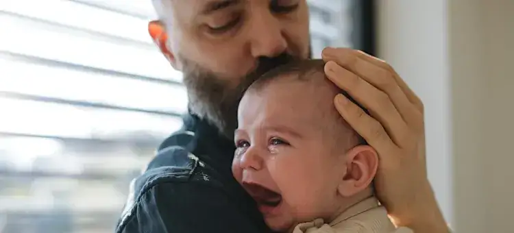 Rodzic przytulający płaczące dziecko